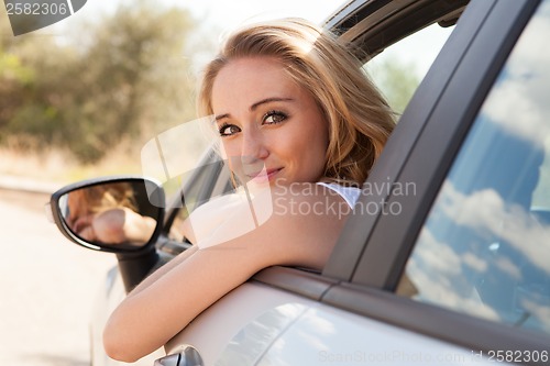 Image of young attractive happy woman sitting in car summertime