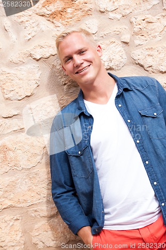 Image of attractive young adult man standing outside 