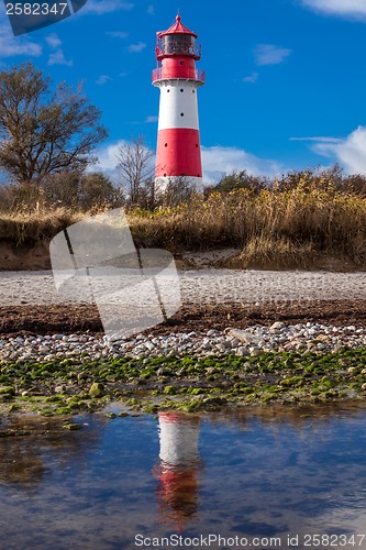 Image of landscape baltic sea dunes lighthouse in red and white 