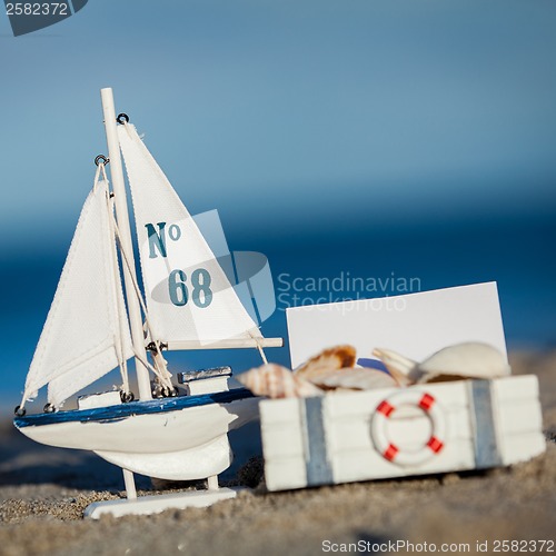 Image of sailing boat and seashell in sand decoration closeup