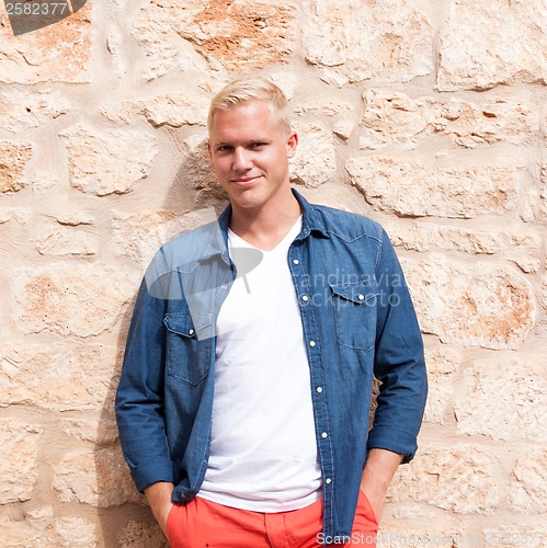 Image of attractive young adult man standing outside 