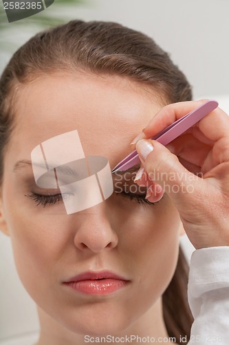 Image of young beautiful woman eyebrow plucking tweezers eyes hair 