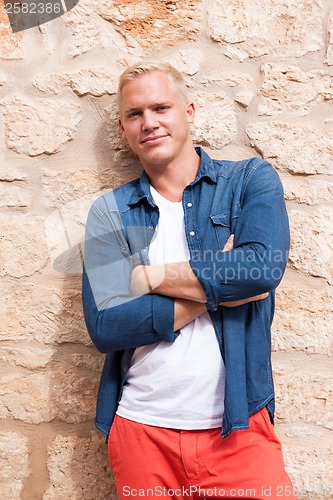 Image of attractive young adult man standing outside 