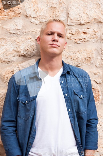 Image of attractive young adult man standing outside 