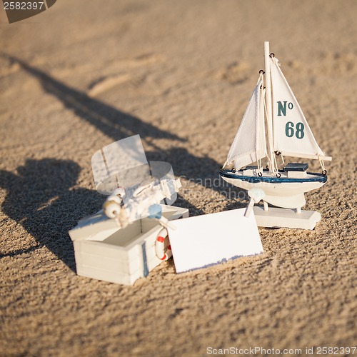 Image of sailing boat and seashell in sand decoration closeup