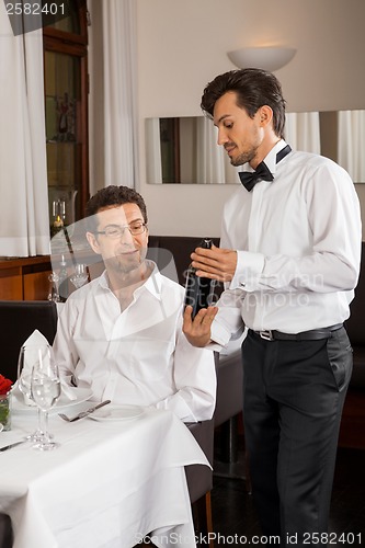 Image of Waiter serving a couple in a restaurant