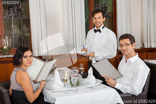 Image of young smiling couple at the restaurant 