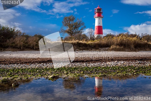 Image of landscape baltic sea dunes lighthouse in red and white 