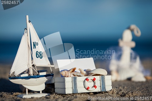 Image of sailing boat and seashell in sand decoration closeup