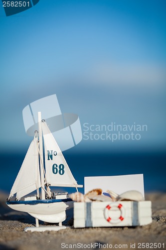 Image of sailing boat and seashell in sand decoration closeup