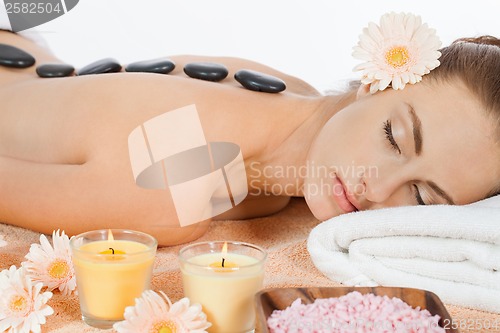 Image of attractive healthy caucasian woman hot stone massage wellness 