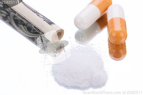 Image of illegal pharmaceutical pills and drugs money on mirror