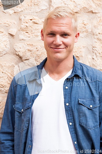 Image of attractive young adult man standing outside 