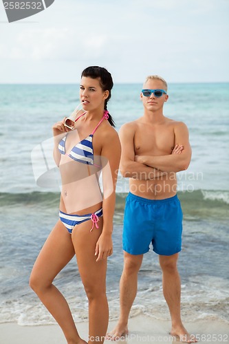 Image of Sexy trendy couple posing in swimwear at the sea