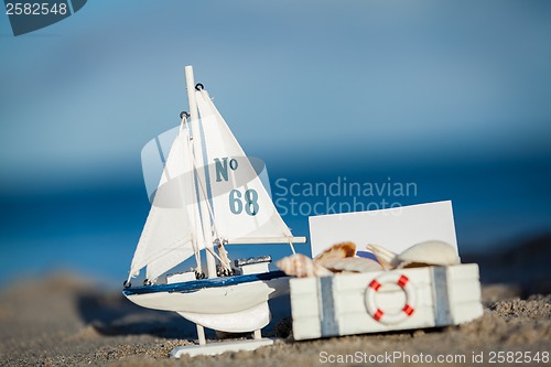 Image of sailing boat and seashell in sand decoration closeup