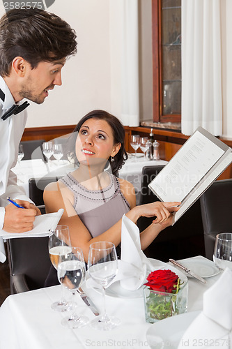 Image of young smiling couple at the restaurant 