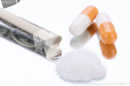 Image of illegal pharmaceutical pills and drugs money on mirror