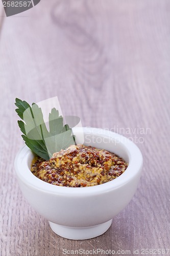 Image of fresh yellow mustard in white bowl with parsley decorated