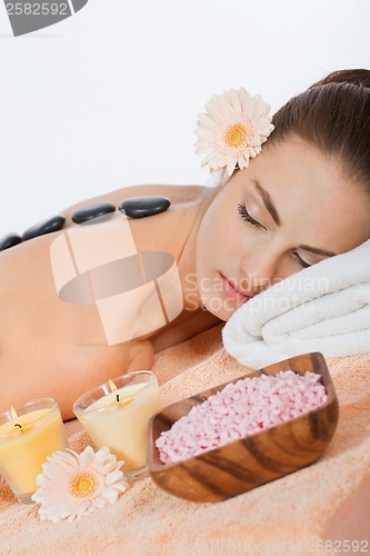 Image of attractive healthy caucasian woman hot stone massage wellness 