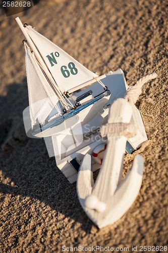 Image of sailing boat and seashell in sand decoration closeup