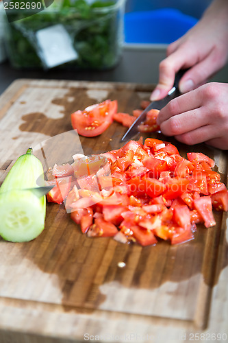 Image of a woman cuts vegetables for a salad