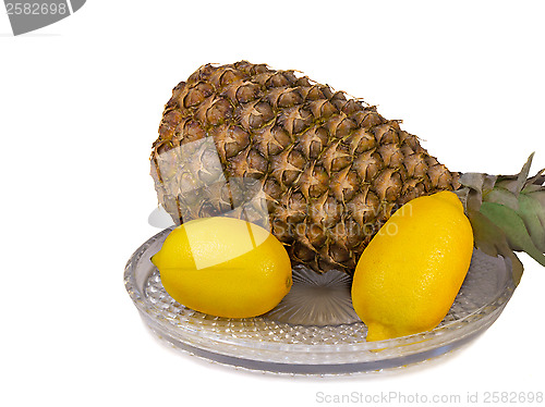 Image of Pineapple and lemons on a platter on a white background.