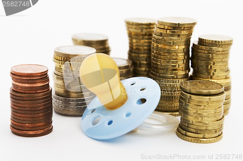 Image of pacifier with hard money in background