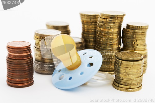Image of pacifier with hard money in background