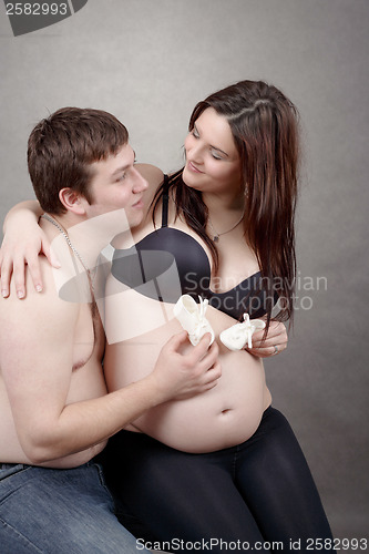 Image of pregnant woman with a child's shoe