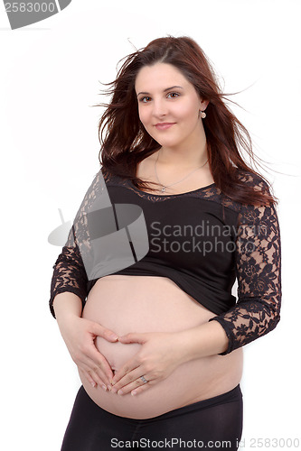 Image of beautiful pregnant woman tenderly holding her tummy isolated on white background