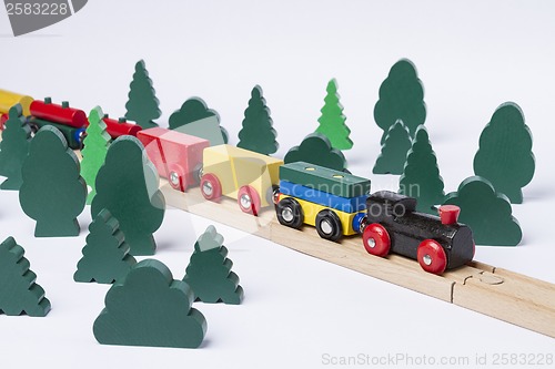 Image of fast train driving through small forest