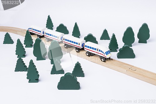 Image of fast train driving through small forest