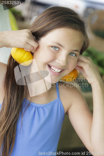 Image of Pretty Young Girl Having Fun with the Pumpkins at Market