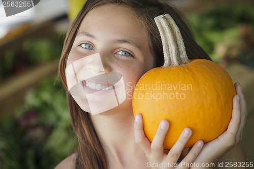 Image of Pretty Young Girl Having Fun with the Pumpkins at Market