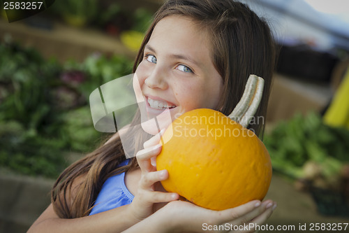 Image of Pretty Young Girl Having Fun with the Pumpkins at Market