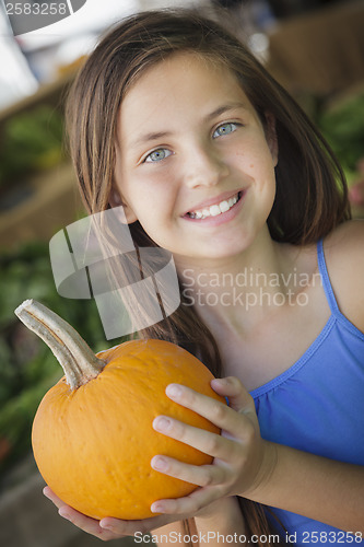 Image of Pretty Young Girl Having Fun with the Pumpkins at Market