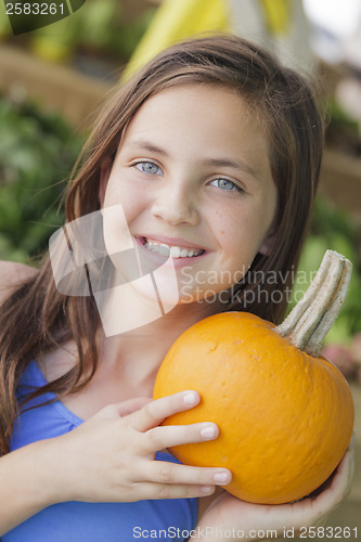 Image of Pretty Young Girl Having Fun with the Pumpkins at Market