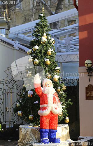 Image of Santa Claus standing near a Christmas tree