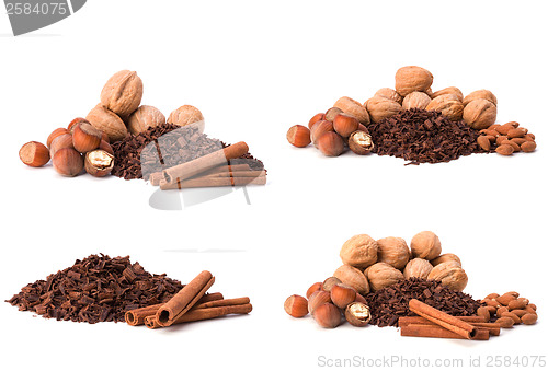 Image of grated chocolate, nuts and cinnamon isolated on white background