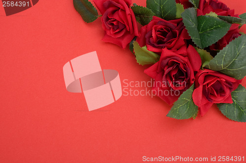 Image of Red background with floral decor. Flowers are artificial. 