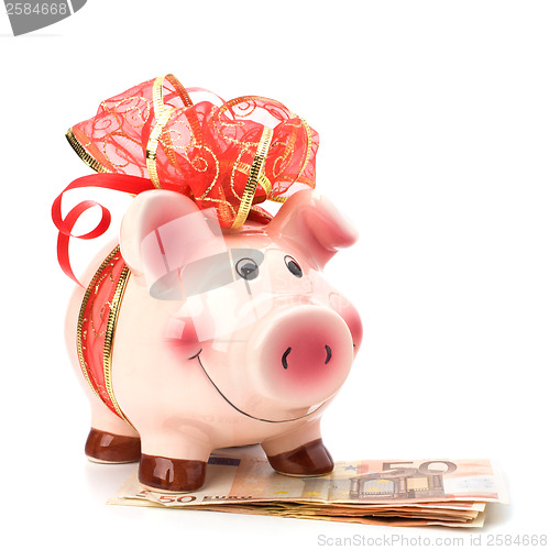 Image of Christmas deposit concept. Piggy bank with festive bow isolated 