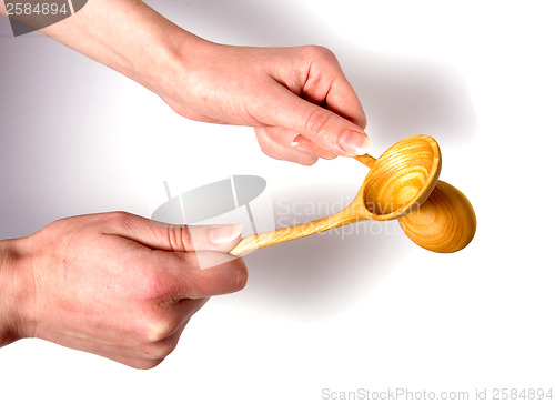 Image of Hand holding wooden spoon isolated on white background