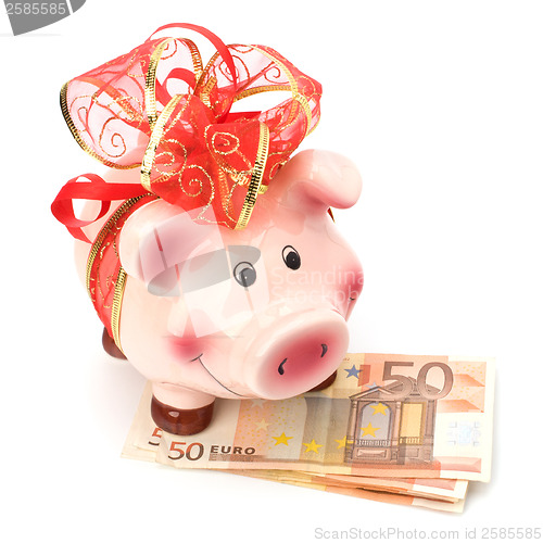 Image of Christmas deposit concept. Piggy bank with festive bow isolated 