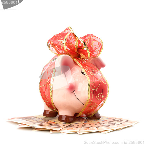 Image of Christmas deposit concept. Piggy bank with festive bow isolated 