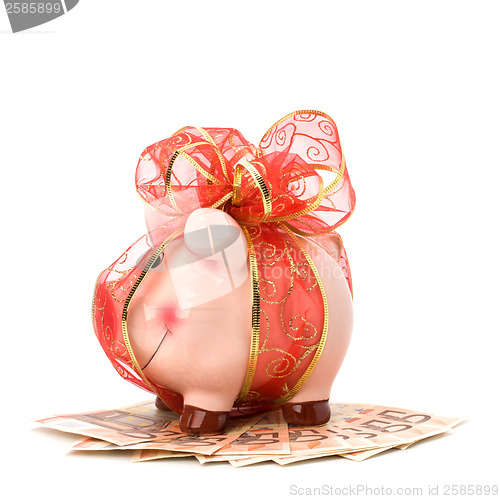 Image of Christmas deposit concept. Piggy bank with festive bow isolated 