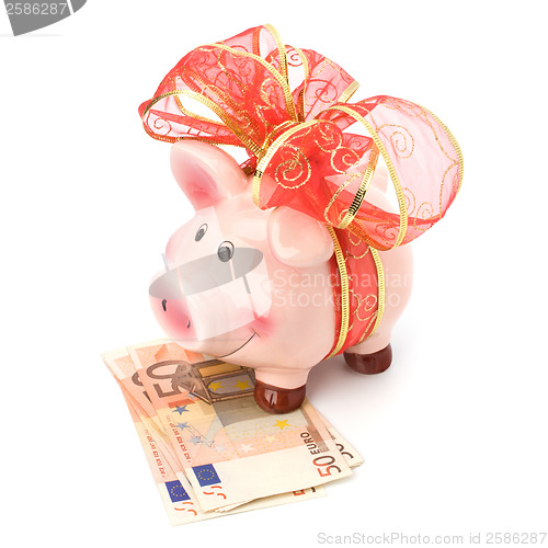 Image of Christmas deposit concept. Piggy bank with festive bow isolated 