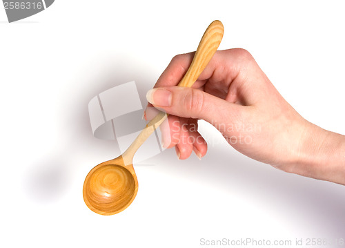 Image of Hand holding wooden spoon isolated on white background 