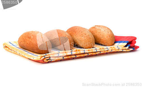 Image of fresh warm rolls over kitchen towel isolated on white background