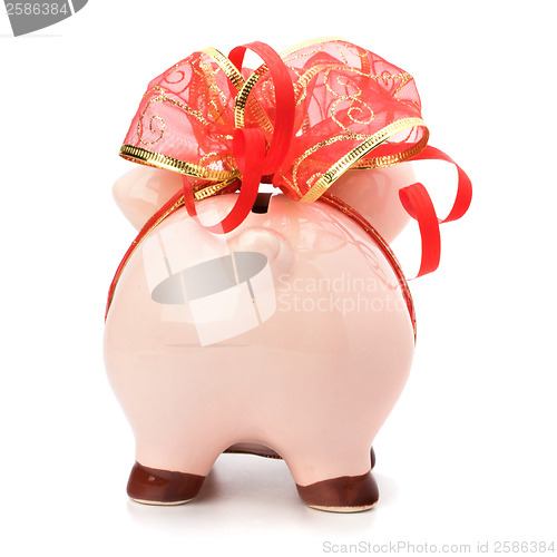 Image of Christmas deposit concept. Piggy bank with festive bow isolated 