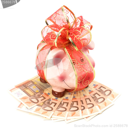 Image of Christmas deposit concept. Piggy bank with festive bow isolated 